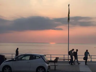 a group of people standing on a pier with a car at Sunny View in Aberystwyth