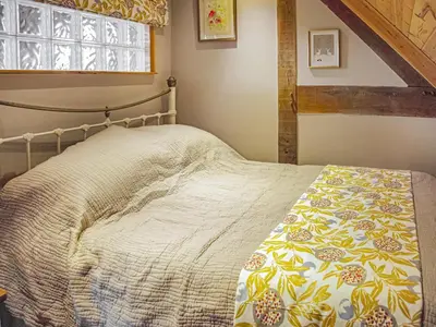 a bed in a bedroom with a window at The Loft At Callow Fold in Eaton