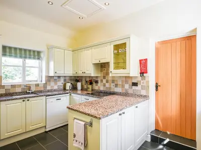 a kitchen with white cabinets and a counter top at Orchard View in Minsterley