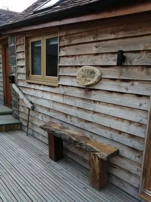 a bench sitting on the side of a house at Cosy and quiet one bed barn conversion. in Church Stretton