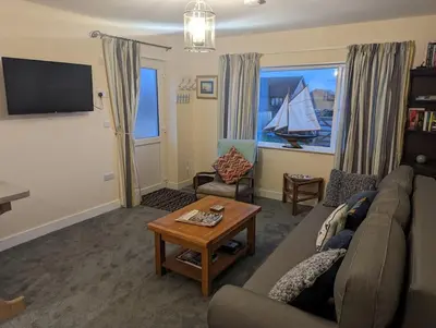 a living room with a couch and a tv at Idyllic, Luxurious Seaside Flat for 4. in Borth