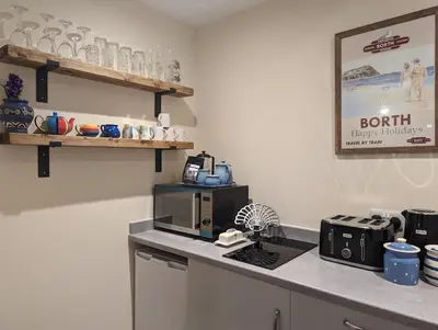 a kitchen with a counter top with a coffee maker at Idyllic, Luxurious Seaside Flat for 4. in Borth