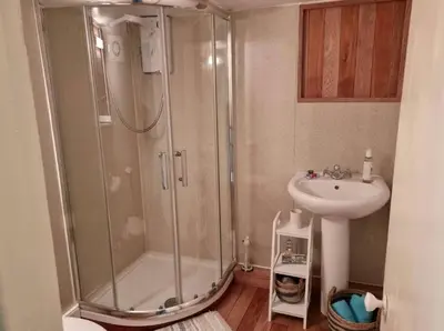 a bathroom with a shower and a sink at Glasfor Cottage in Llwyngwril