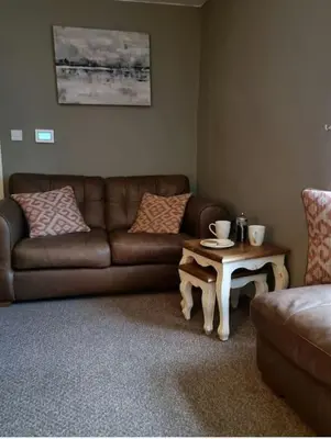 a living room with a couch and a coffee table at Glasfor Cottage in Llwyngwril