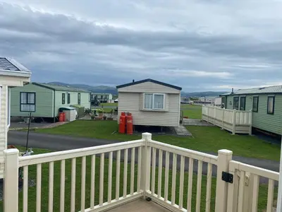 a porch of a house with a white fence at 98Lemmington by the beach Ynyslas, Borth in Borth