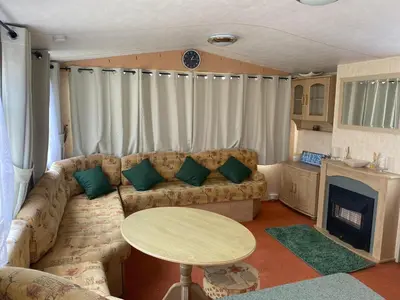 a living room with a couch and a table at 98Lemmington by the beach Ynyslas, Borth in Borth