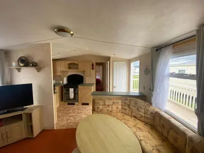 a living room with a couch and a kitchen at 98Lemmington by the beach Ynyslas, Borth in Borth