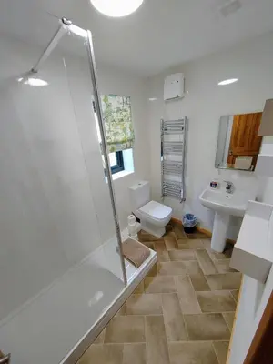 a bathroom with a shower and a toilet and a sink at Bryn Mynach Annex in Barmouth