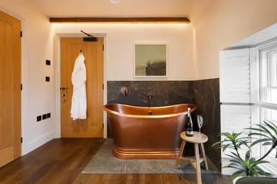 a bathroom with a copper tub in a room at Hive Townhouse in Aberaeron