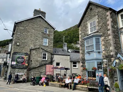 a group of people sitting outside of a building at Glanywerydd Cottage in Barmouth