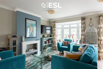 a living room with blue chairs and a tv at 4 Bedroom Townhouse 10mins walk from Shrewsbury Town Centre with Parking in Shrewsbury
