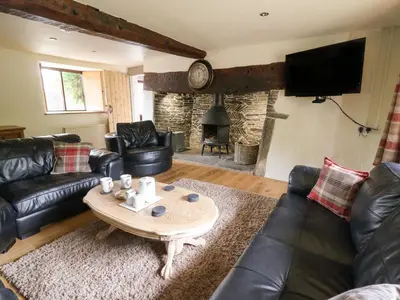 a living room with black leather furniture and a table at Penarth in Llandrindod Wells