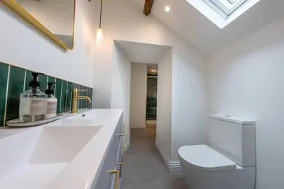 a white bathroom with a toilet and a sink at Stylish, comfortable, convenient! in Bala