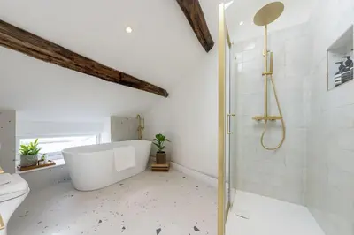 a bathroom with a tub and a shower and a toilet at Stylish, comfortable, convenient! in Bala
