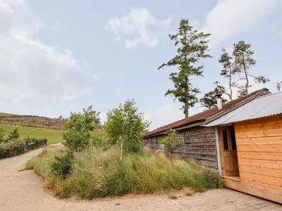 a cabin with a field in the background at Y Caban in Llangollen