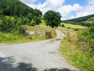 a dirt road in a field with a fence at Barcud Coch - Uk44539 in Hirnant