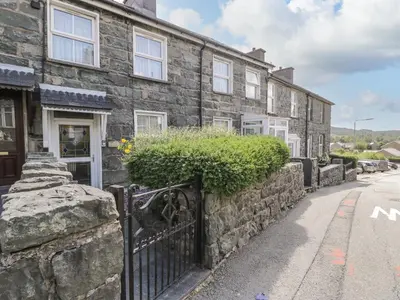 a stone house with a gate in front of a street at Bodalaw in Trawsfynydd