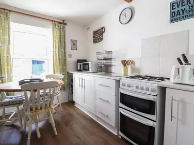 a kitchen with a stove and a table at Bodalaw in Trawsfynydd