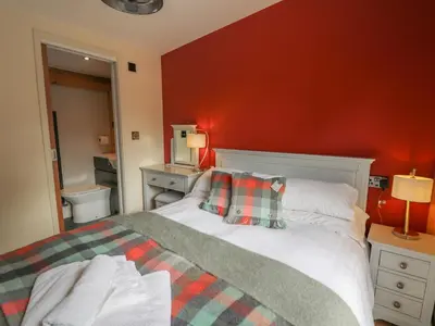 a bedroom with a bed and a red wall at Pansi in Welshpool
