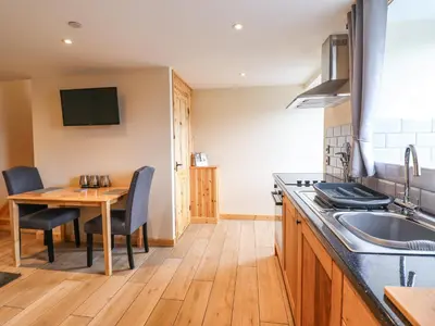 a kitchen with a wooden table and a wooden floor at Hen Blaid in Oswestry