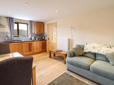 a living room with a couch and a kitchen at Hen Blaid in Oswestry