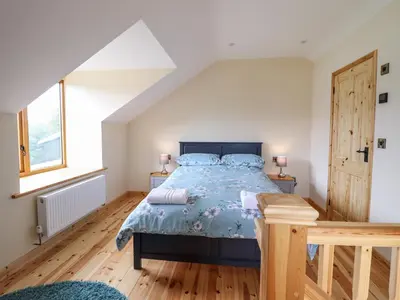 a bedroom with a bed with a blue comforter at Hen Blaid in Oswestry