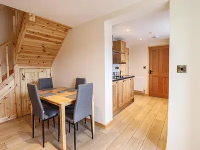 a kitchen and dining room with a wooden table and chairs at Llety Dewi in Oswestry
