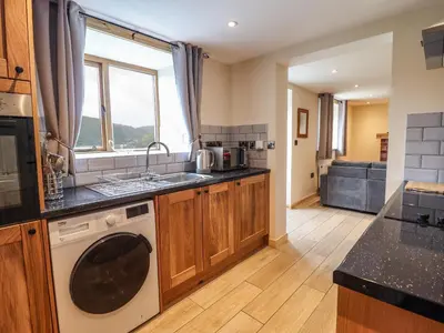 a kitchen with a washer and dryer in it at Llety Dewi in Oswestry