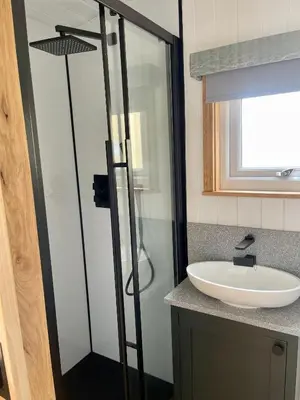 a bathroom with a shower and a sink at Cwtch Cader Shepherds Hut in Llanelltyd