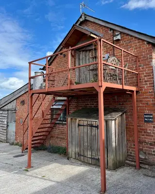 a brick building with a staircase on the side of it at The Hayloft in Hereford