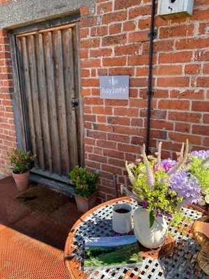 a table with vases and flowers on a patio at The Hayloft in Hereford