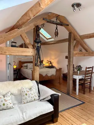 a bedroom with a bed and a table with a desk at The Hayloft in Hereford