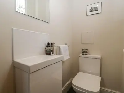a white bathroom with a toilet and a sink at The Old Chapel in Hereford