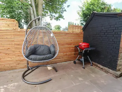 a chair sitting on a patio next to a fence at The Old Chapel in Hereford