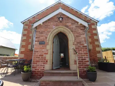 a small brick chapel with a white door at The Old Chapel in Hereford