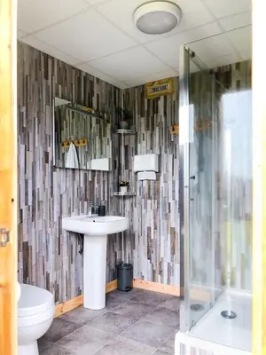 a bathroom with a sink and a toilet and a shower at Tinker the Bell Tent at Pentref Luxury Camping in Penuwch