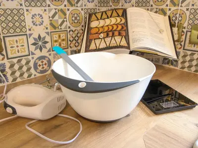a white bowl with a spoon and a book on a counter at Clematis Cottage in Shrewsbury