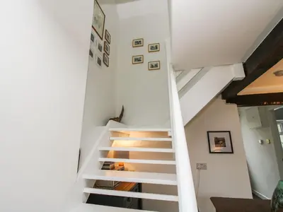 a staircase in a house with white walls at Clematis Cottage in Shrewsbury