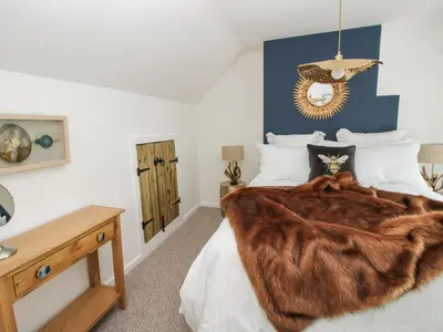 a bedroom with a bed with a fur blanket at Clematis Cottage in Shrewsbury