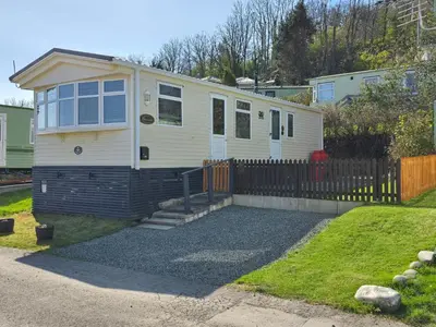 a tiny house with a fence in a yard at Wonderful 2 bedroom mobile home in Aberystwyth