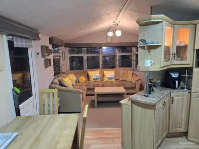 a kitchen and a living room with a couch at Wonderful 2 bedroom mobile home in Aberystwyth