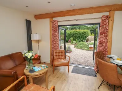 a living room with a couch and a sliding glass door at Fioled in Welshpool