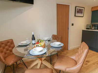 a dining room with a glass table and chairs at Celyn in Welshpool