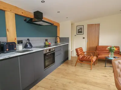 a kitchen with gray counters and a table and a chair at Celyn in Welshpool