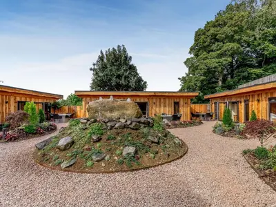 a garden with a rock in front of a building at Rhosyn - Uk40260 in Llangadfan