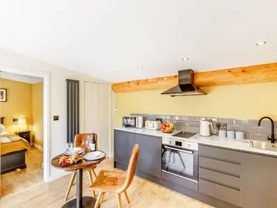 a kitchen with a table and chairs in a room at Rhosyn - Uk40260 in Llangadfan