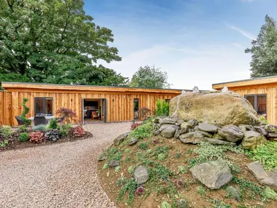 a wooden house with a large rock in the yard at Celyn - Uk40258 in Llangadfan