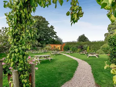 a park with picnic tables and benches in the grass at Celyn - Uk40258 in Llangadfan