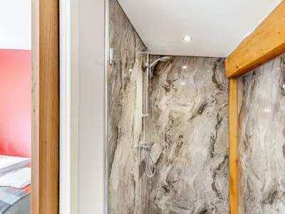 a shower in a room with a stone wall at Pansi - Uk40263 in Llangadfan