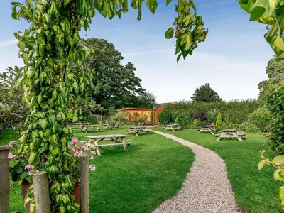 a garden with picnic tables and benches in the grass at Fioled - Uk40267 in Llangadfan